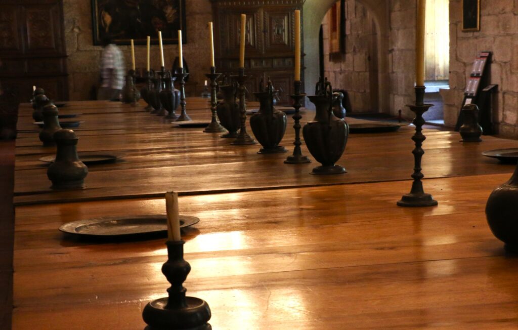 The Banqueting Hall inside the Palace of the Dukes of Braganza, featuring a long wooden table and a high vaulted chestnut ceiling.