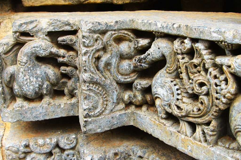 Bird feeding chicks - sculpture on horizontal band of the temple base
