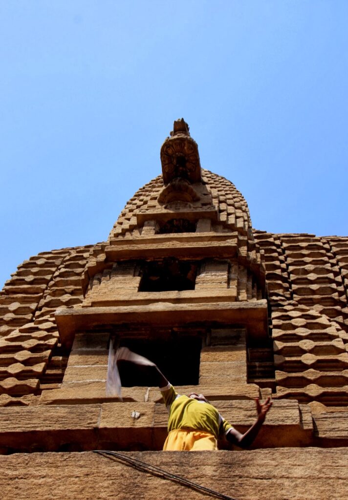 Boy flying paper plane from Temple roof
