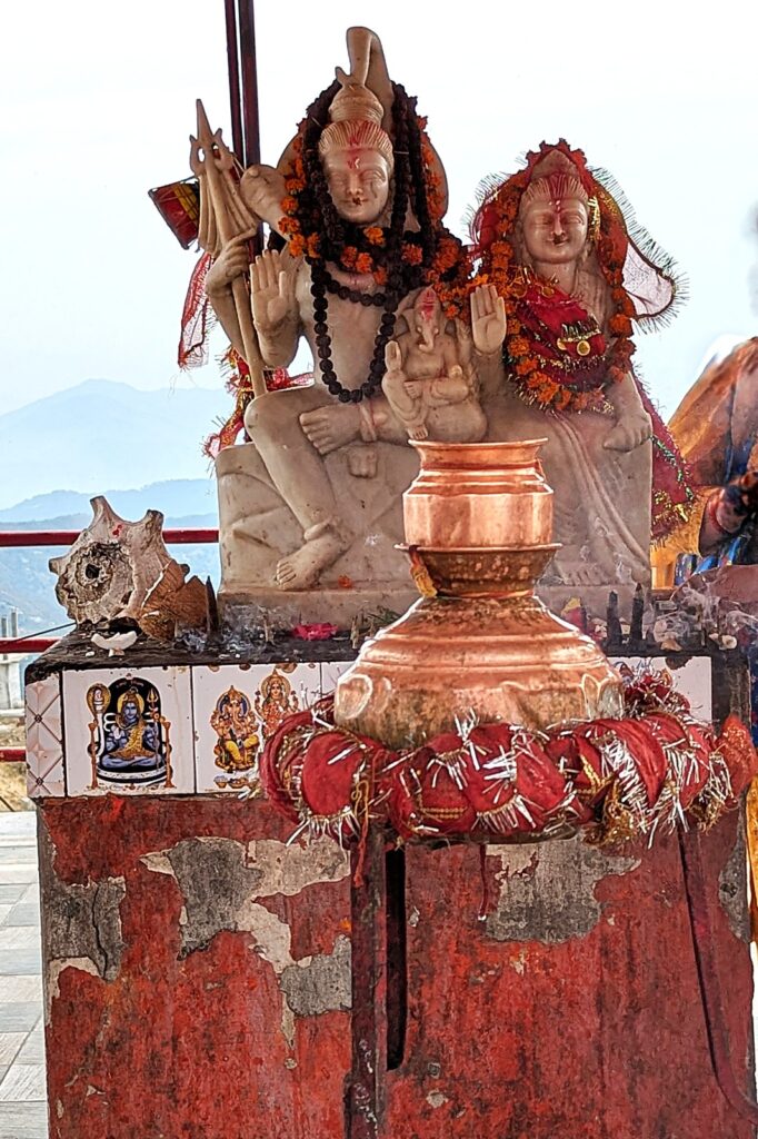 A dedicated shrine within the Surkanda Devi complex featuring a detailed statue of Lord Shiva and Goddess Parvati.