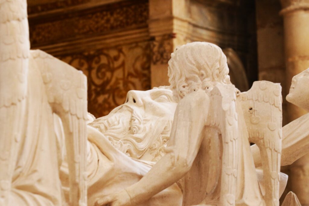 Six angels cradle the King’s Head and Feet