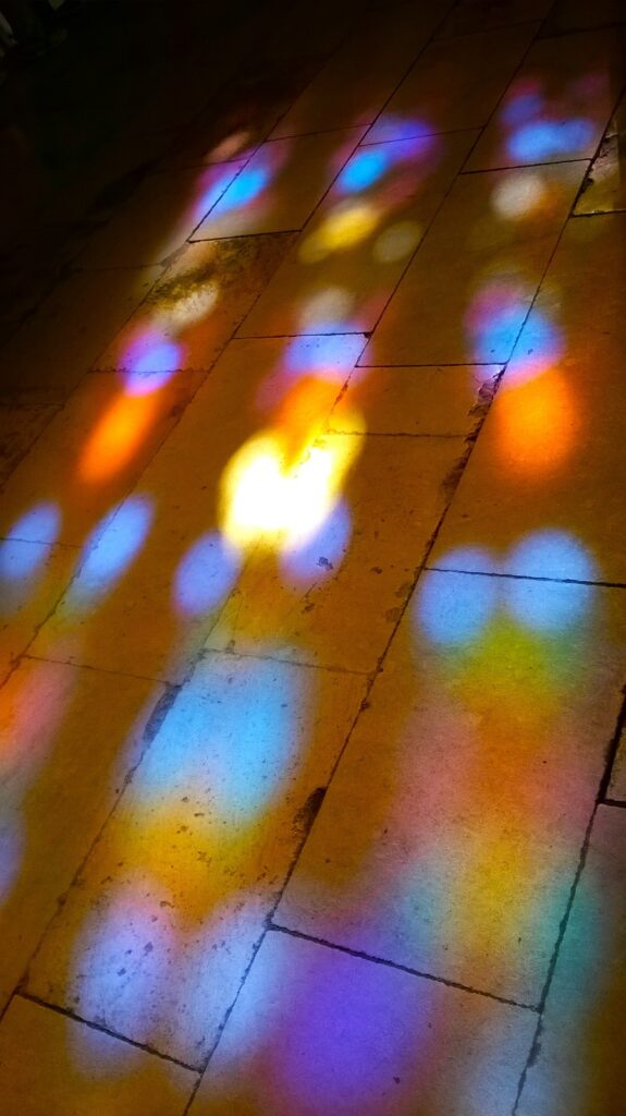 Sunlight streamed through the stained-glass windows