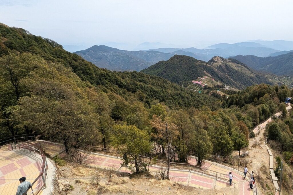 Aerial view of the steep 2.5 km paved walking trek from Kaddukhal to Surkanda Devi, seen from the ropeway cabin.