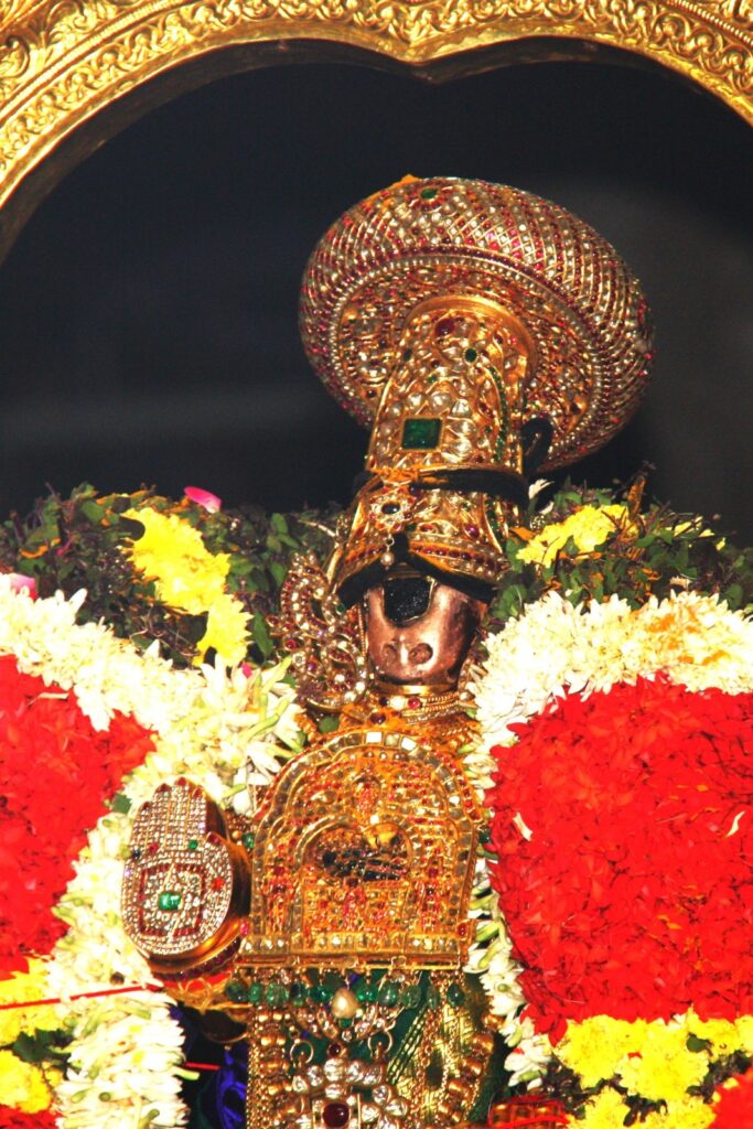 Detailed close-up of the Namperumal Utsavar idol at Srirangam Temple, showing the intricate craftsmanship and shiny golden surface of the processional deity.